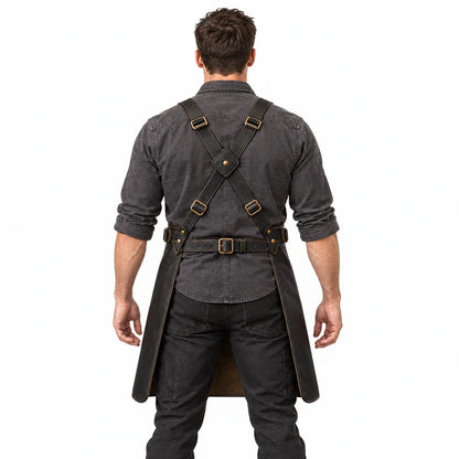 Rear studio view of blacksmith apron on male model displaying crossed leather shoulder straps, central keeper and adjustable waist belt.