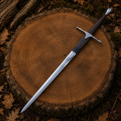Full-length Braveheart William Wallace Sword Replica with high carbon steel blade displayed diagonally on a woodland tree stump