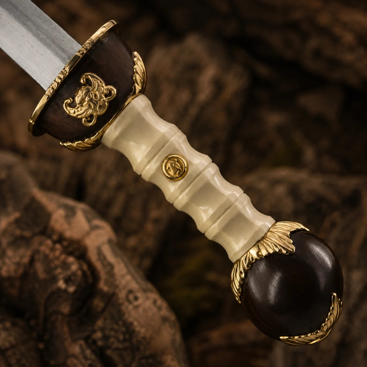 Close-up of the Gladiator Maximus sword handle featuring faux ivory grip, decorative gold details and dark rounded pommel