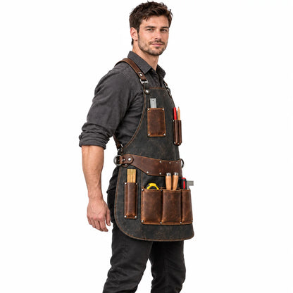 Side profile of male model wearing a distressed charcoal leather workshop apron with brown tool pockets and shoulder straps.