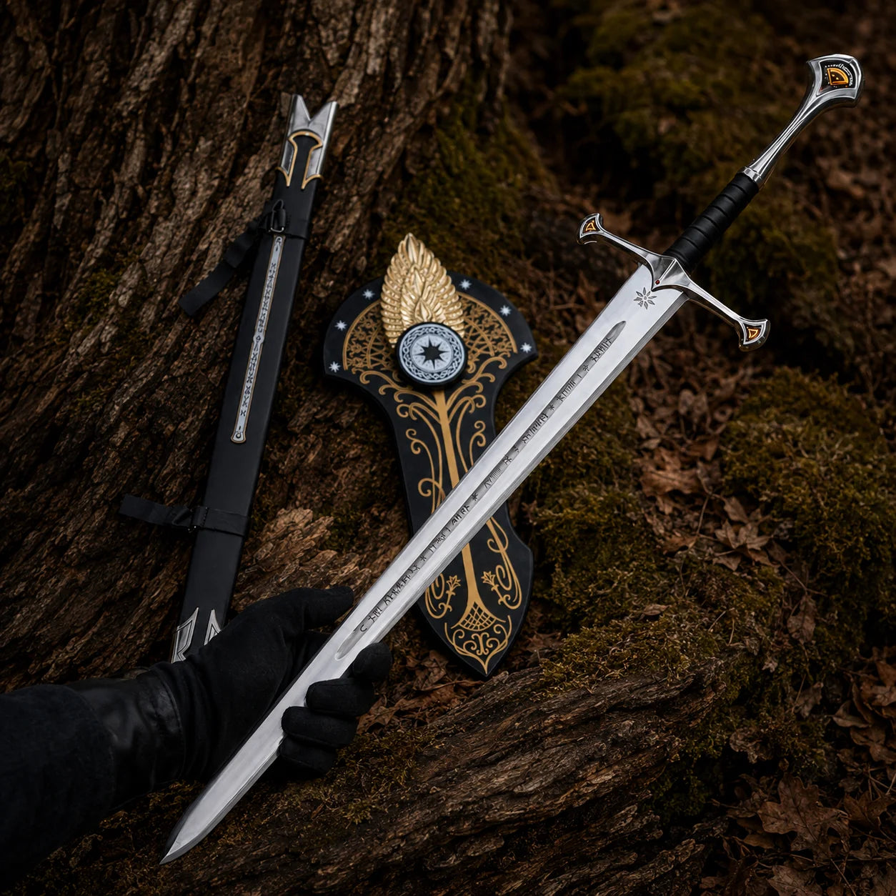 Aragorn-inspired Anduril sword held in a black-gloved hand in woodland beside scabbard and ornate display plaque