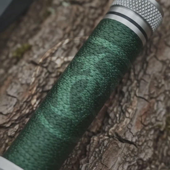 Cinematic product showcase of the Rambo First Blood Part I Signature Edition decorative replica, highlighting its silver sawback-style blade, green wrapped handle, metal pommel and black stitched leather sheath.