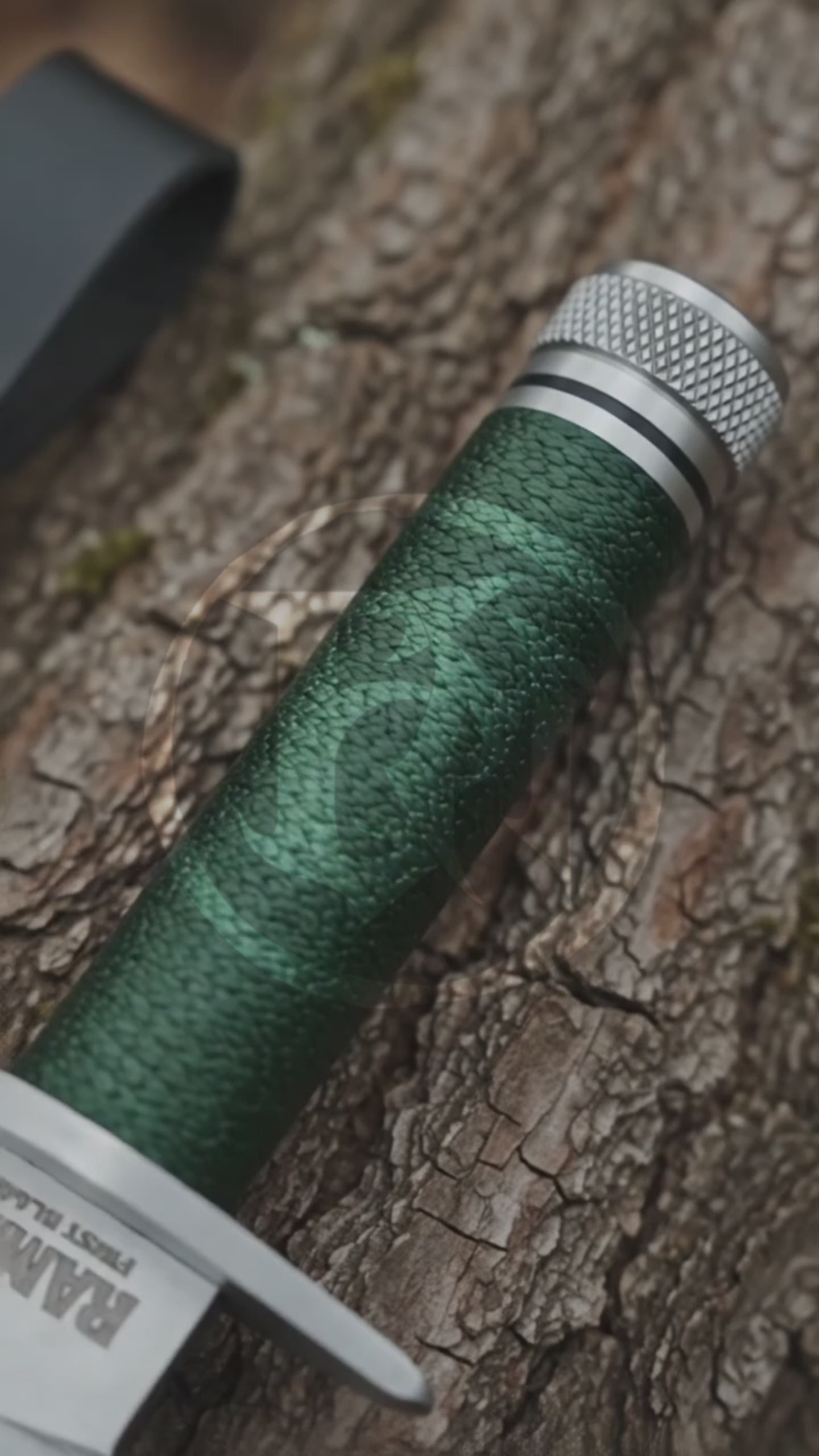 Cinematic product showcase of the Rambo First Blood Part I Signature Edition decorative replica, highlighting its silver sawback-style blade, green wrapped handle, metal pommel and black stitched leather sheath.
