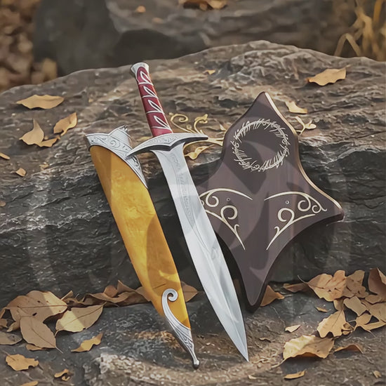 Product video showing the High Elven Warrior Sword replica with its engraved silver blade, red grip, brown scabbard and decorative Elven wall plaque in an outdoor woodland setting.