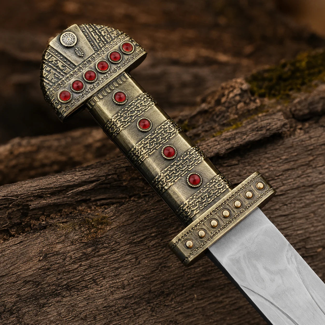 Close-up of the Ragnar Lothbrok Viking sword handle featuring antique gold metalwork, red jewel inlays and detailed pommel
