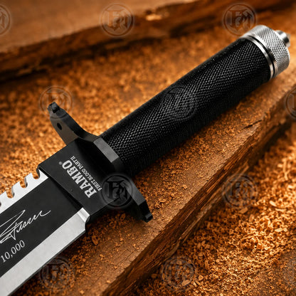Close-up of Rambo II knife handle showing black textured wrap, guard and silver-toned textured pommel cap.