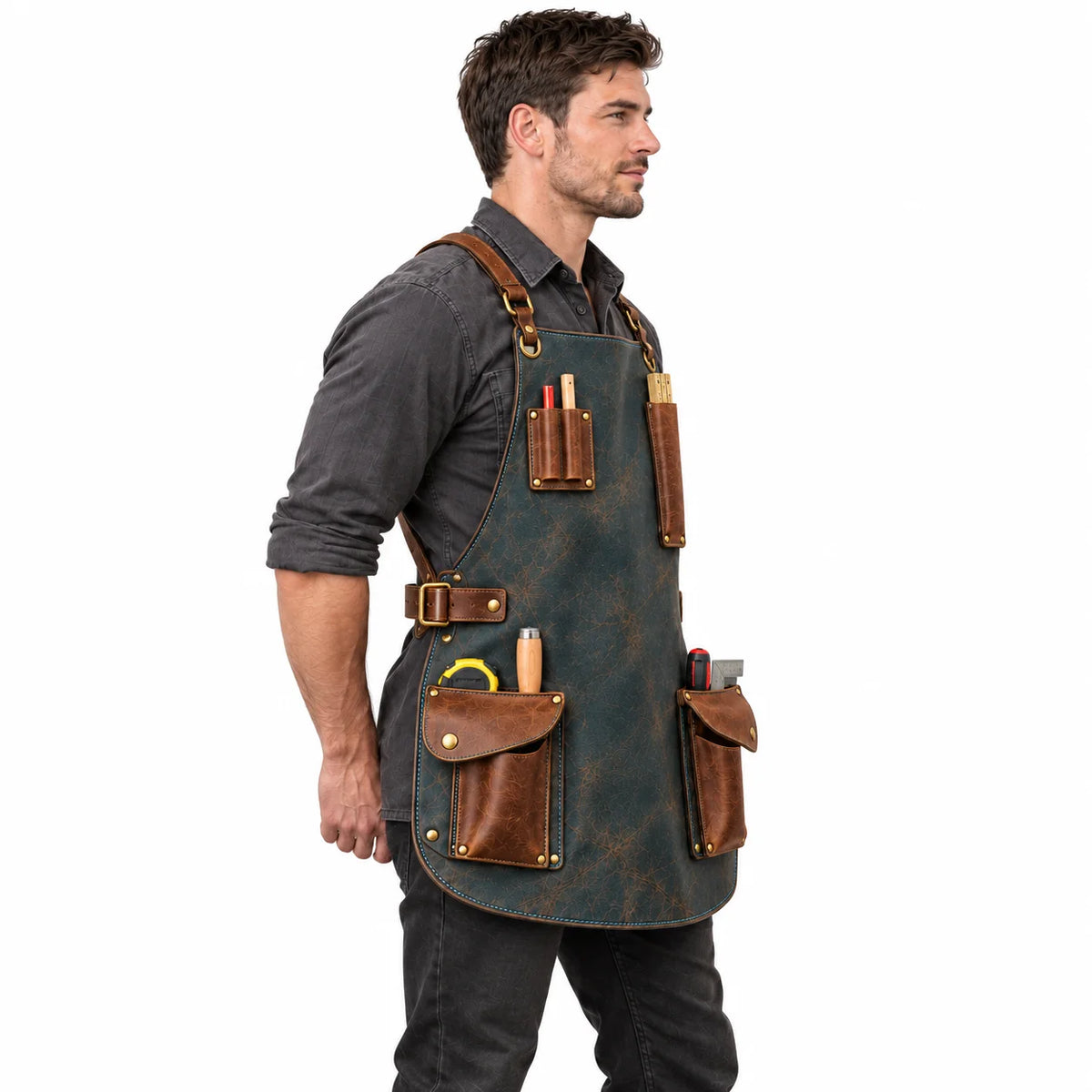 Side profile of a woodworker wearing a distressed slate teal leather apron with brown utility pouches and brass-tone side buckles.